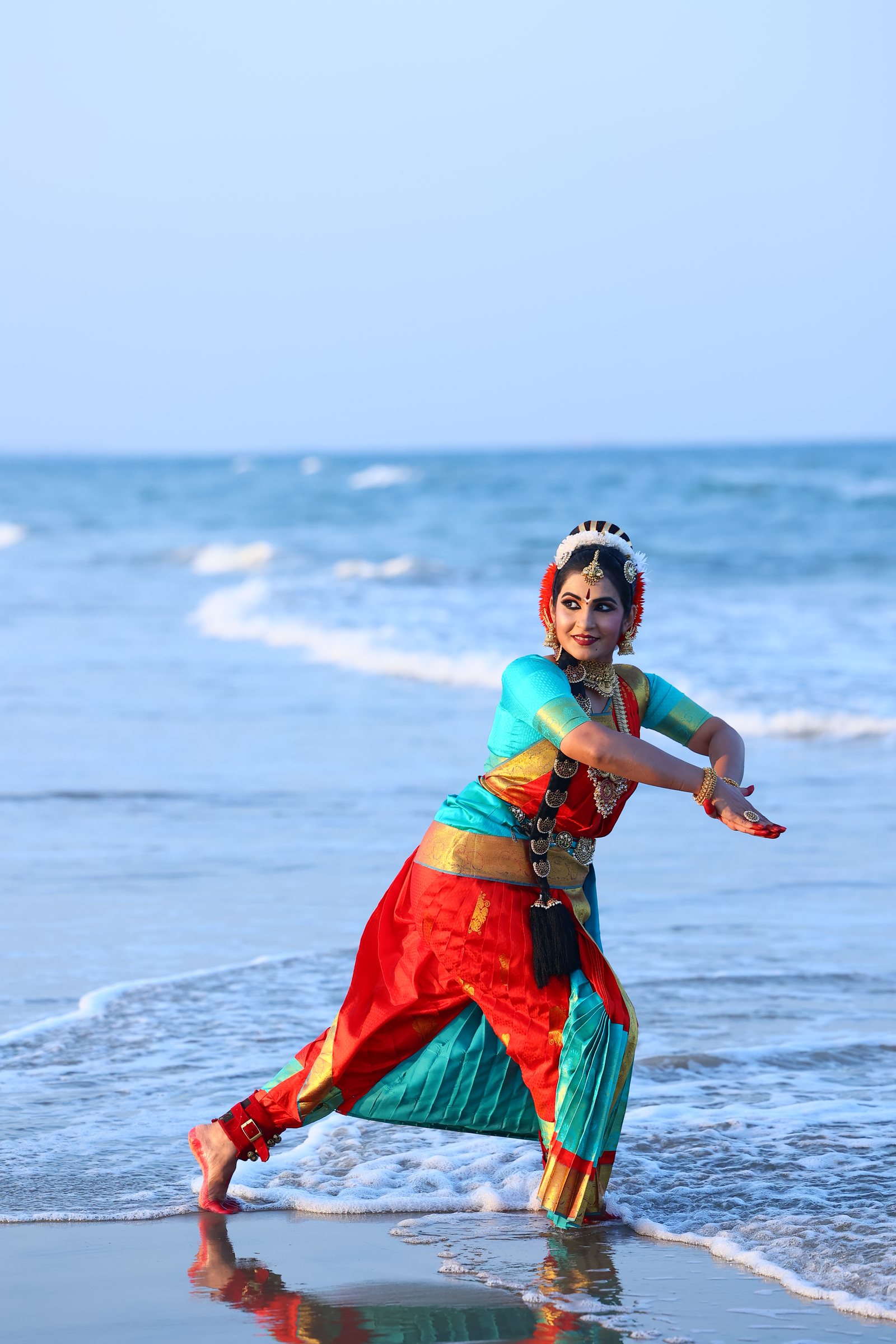 Smt. Pooja Raj in Bharatanatyam costume, dancing in the shallows at the shoreline