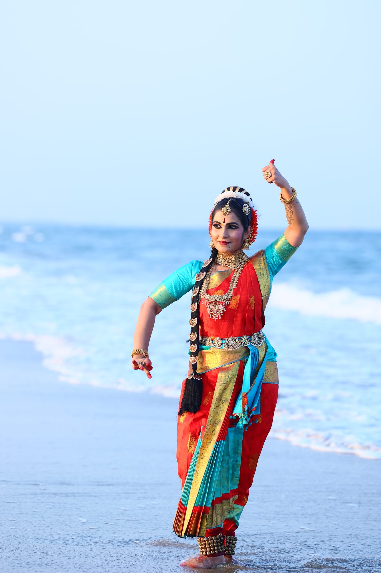 Smt. Pooja Raj dancing in the shallows, arms raised